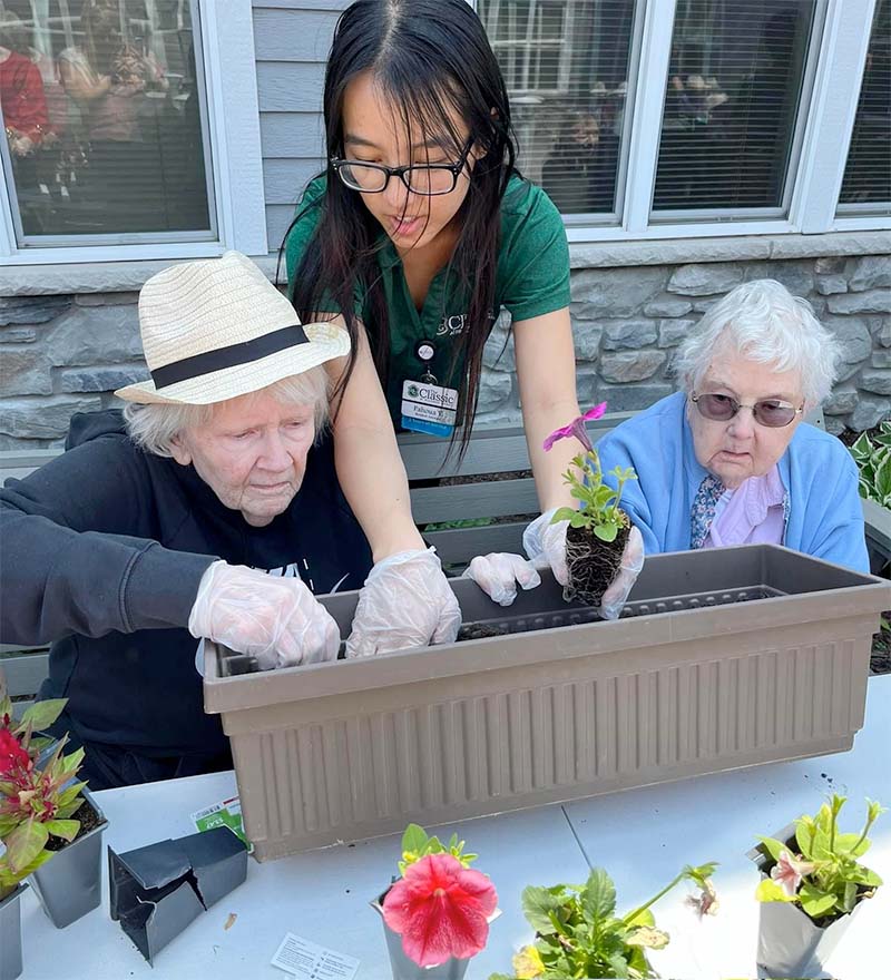 Employee planting flowers with residents